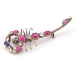 Unmarked gold scorpion bar brooch set with diamonds, cabochon rubies and blue sapphires, the largest
