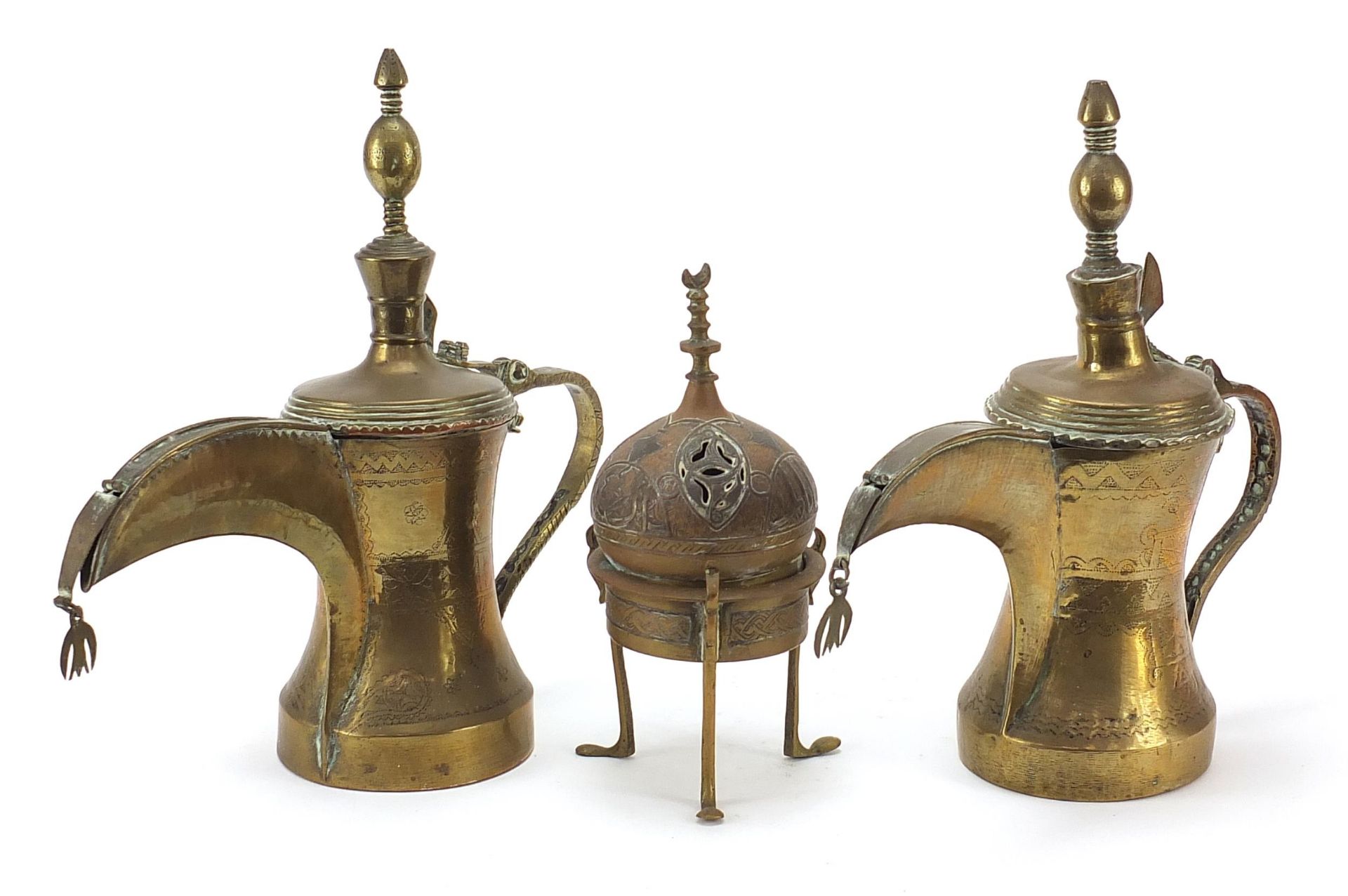 Middle Eastern metalware comprising two Omani Dallah coffee pots and a Cairoware incense burner with