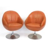 Pair of vintage egg type tub chairs, signs of paper labels to the underside, each 78cm high