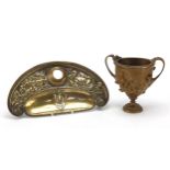 Elkington & Co classical brass ink stand and a twin handled cup decorated in relief with figures,