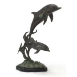 Bronze dolphin group raised on a shaped black slate base, 36cm high