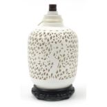 Chinese porcelain blanc de chine pierced table lamp raised on a carved hardwood base, 27cm high