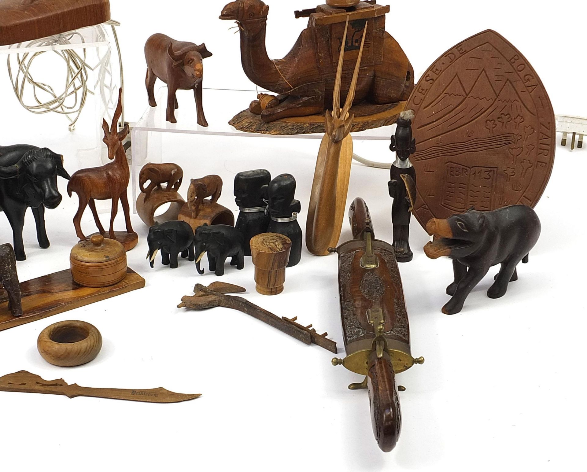 African woodenware to include carved elephants, table lamp, wall plaque, figures and a carving - Image 5 of 7