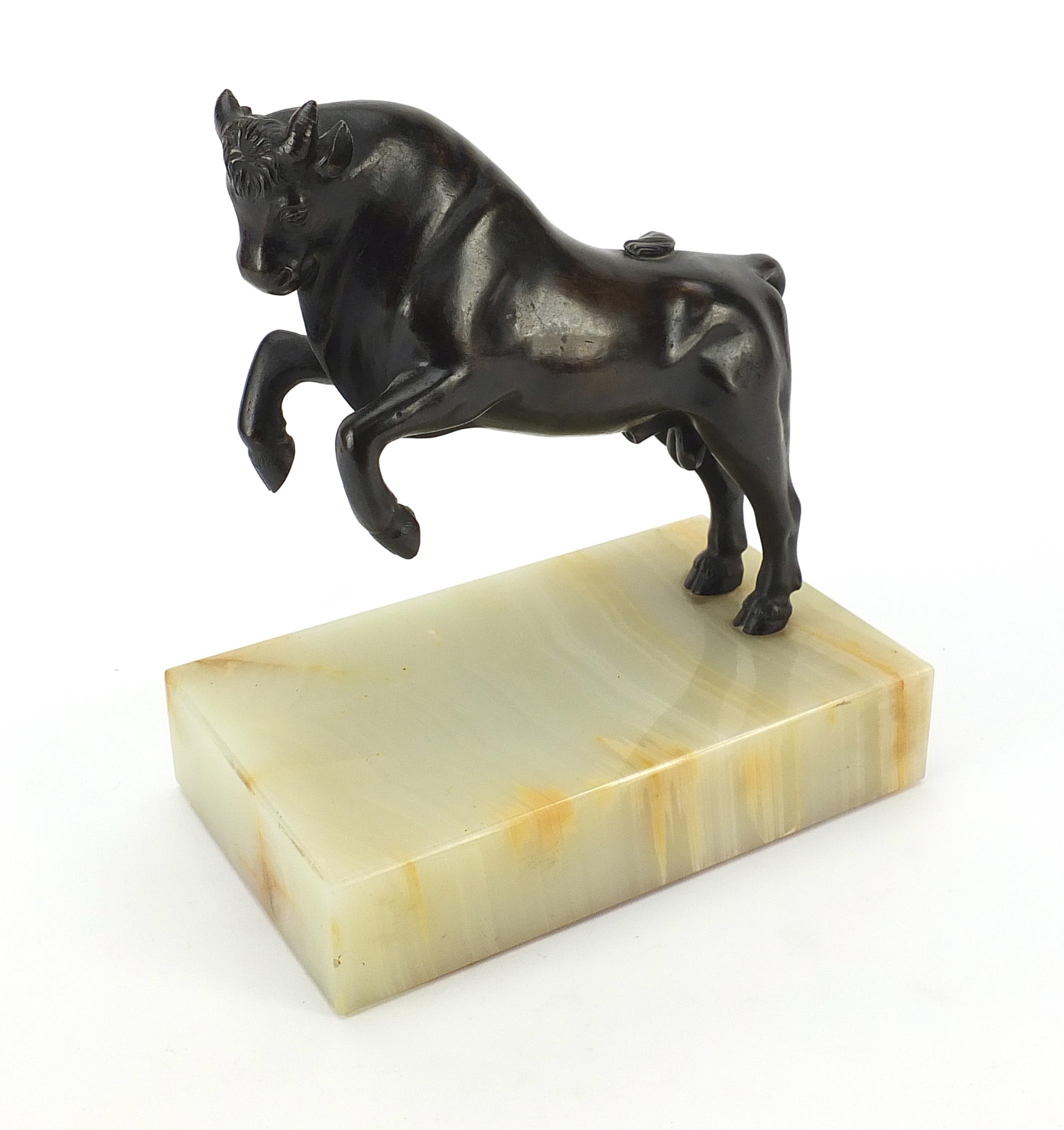 Patinated bronze study of a rearing bull raised on rectangular onyx base, 19cm high