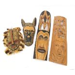 Four carved African wall masks, one with a crocodile, the largest 91cm high