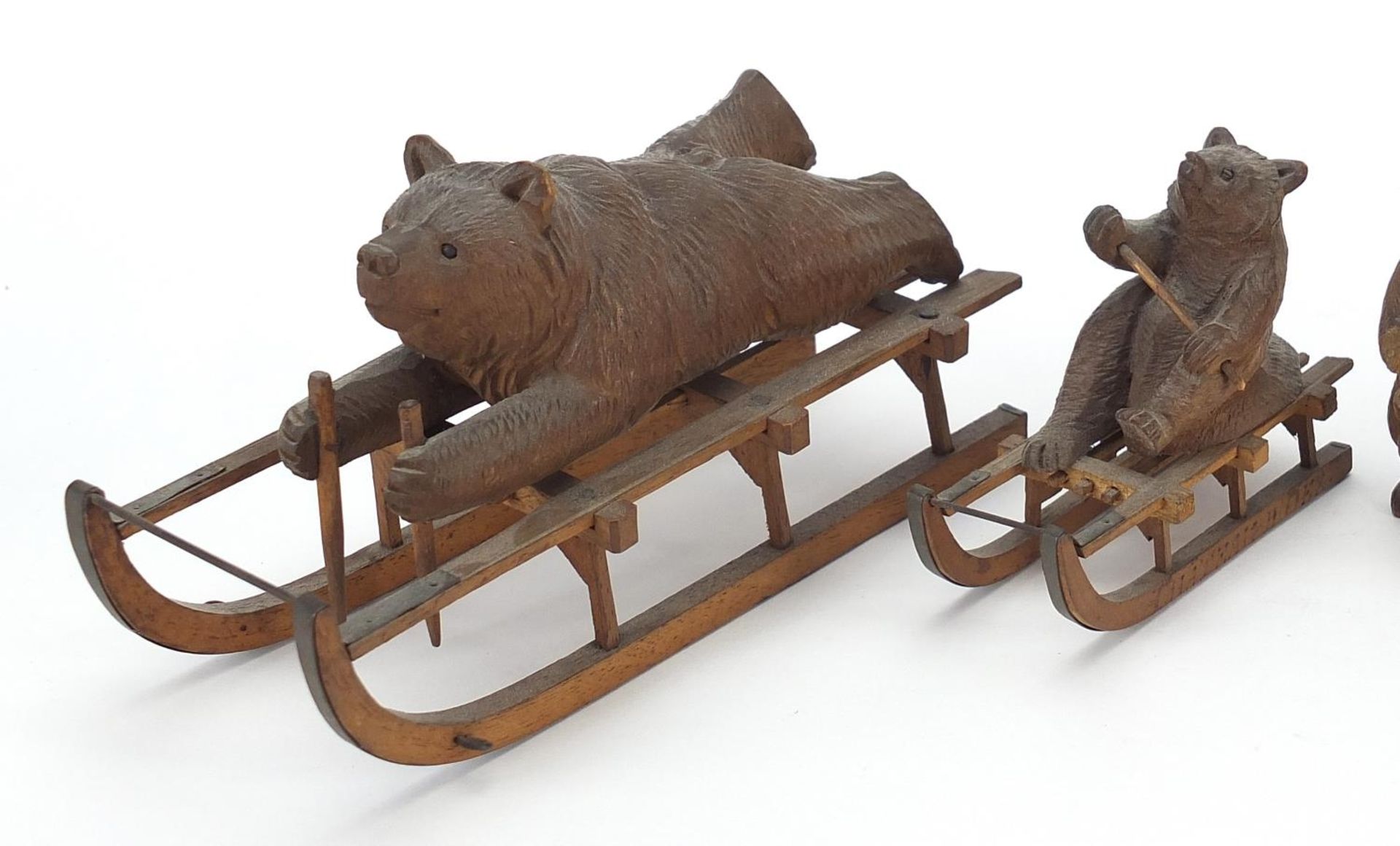 Three carved Black Forest bears and a matchbox including two riding sleds, the largest 15cm in - Image 2 of 5