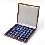Thirty six royal crystal cameos by the Danbury Mint housed in a mahogany box, 3.5cm H x 35.5cm W x