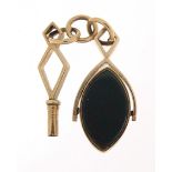 Unmarked gold bloodstone and carnelian spinner fob and a gold coloured metal watch key, the fob