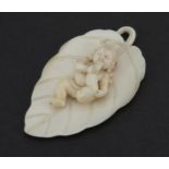 Carved ivory pendant carved with a baby on a leaf, 6.5cm in length, 9.0g
