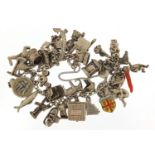Silver charm bracelet with a large selection of mostly silver charms including Buddha, cuckoo clock,