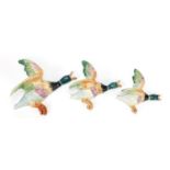 Three porcelain flying ducks wall plaques, the largest 17cm in length