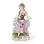 German porcelain figure of a lady with a hat on her knee, 14.5cm high