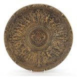 Bronze dish decorated in relief with children and animals having a crest in the centre, 37cm in