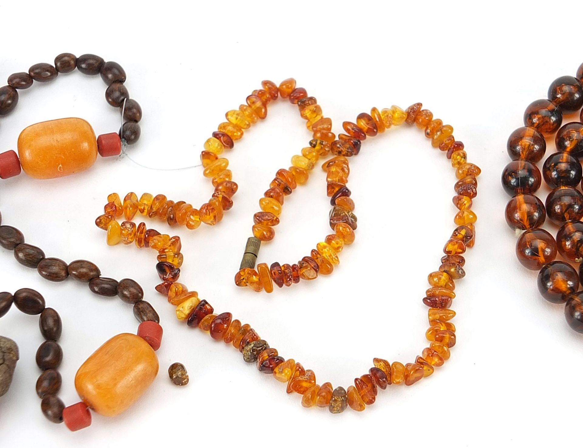 Two amber coloured necklaces and a nut necklace, the largest 80cm in length, total 142.6g - Image 3 of 4