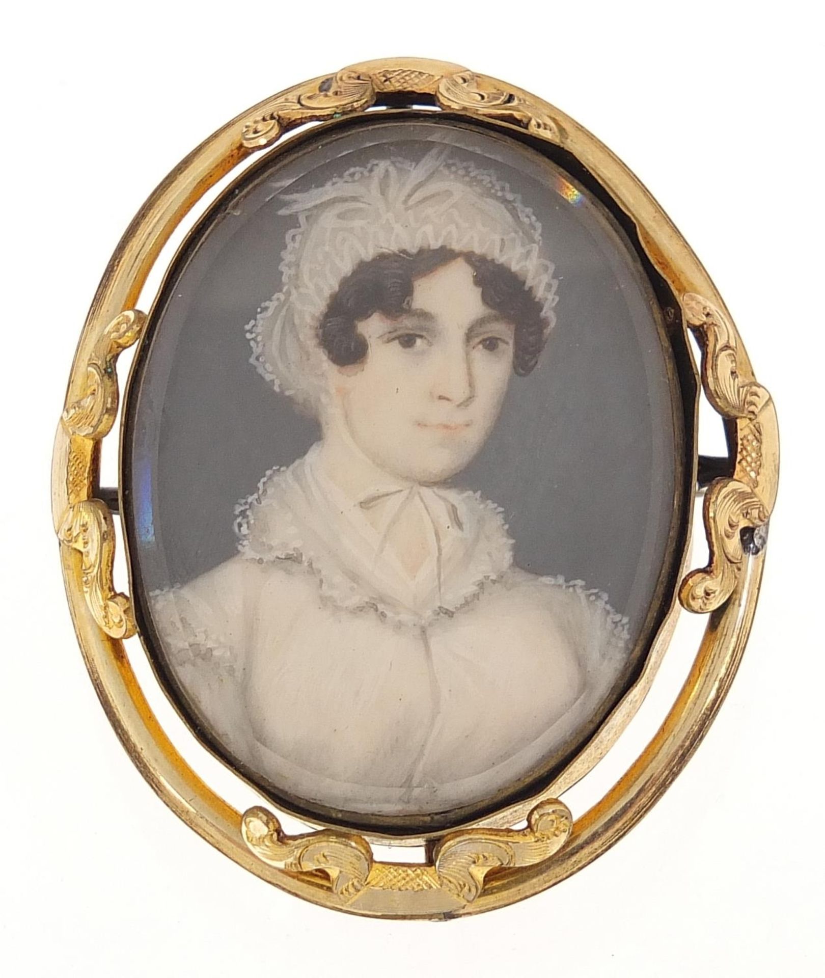 Oval hand painted portrait miniature of a female in Georgian dress housed in a gilt metal brooch