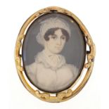 Oval hand painted portrait miniature of a female in Georgian dress housed in a gilt metal brooch