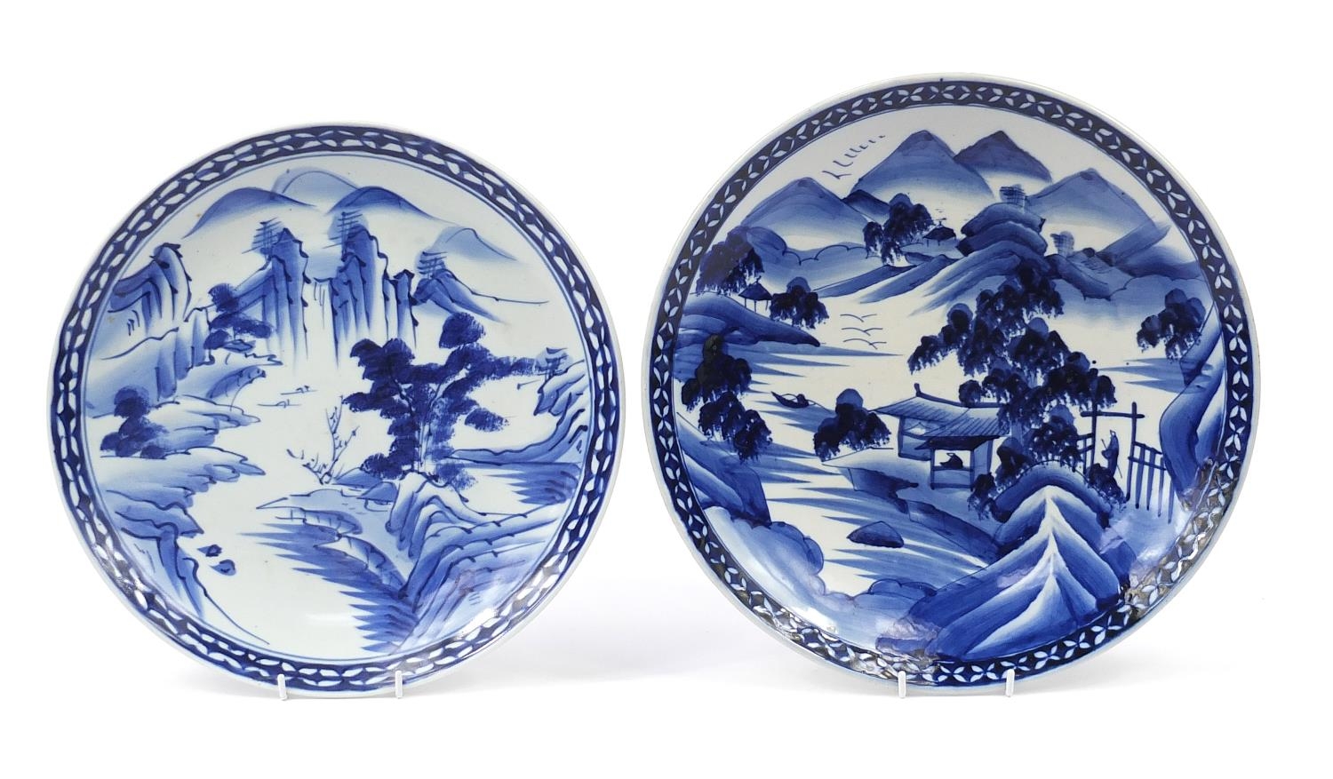 Two Japanese blue and white porcelain chargers, hand painted with mountainous landscapes, the