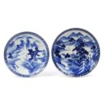 Two Japanese blue and white porcelain chargers, hand painted with mountainous landscapes, the
