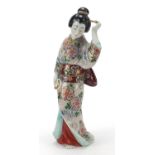 Japanese porcelain figure of a Geisha girl playing with her hair, 32cm high