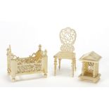 Carved ivory doll's house chair, bed and clock, the largest 5cm high