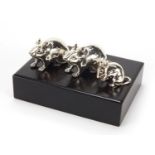 Set of three modern miniature silver mice on a hardwood stand, the largest mouse 4.5cm in length,