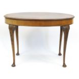 Oval walnut centre table with quarter veneered top on cabriole legs and shell carved knees, 70cm H x