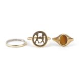 Three 9ct gold rings including tiger's eye signet ring and a white gold wedding band, sizes I, L and
