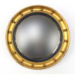 Circular gilt framed porthole design convex mirror, with J Davey & Sons label, 47cm in diameter