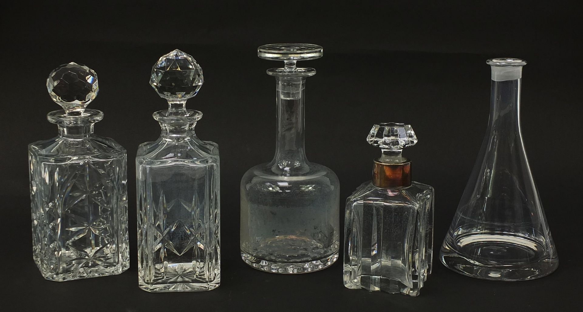 Five cut glass decanters including one with a silver plated collar and one Swedish design, the