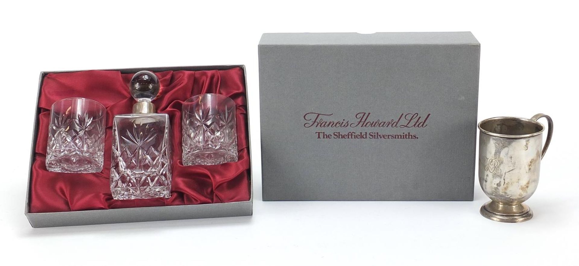 Francis Howard cut glass bottle and two glasses with silver collar and a silver cup, the cup 8.5cm