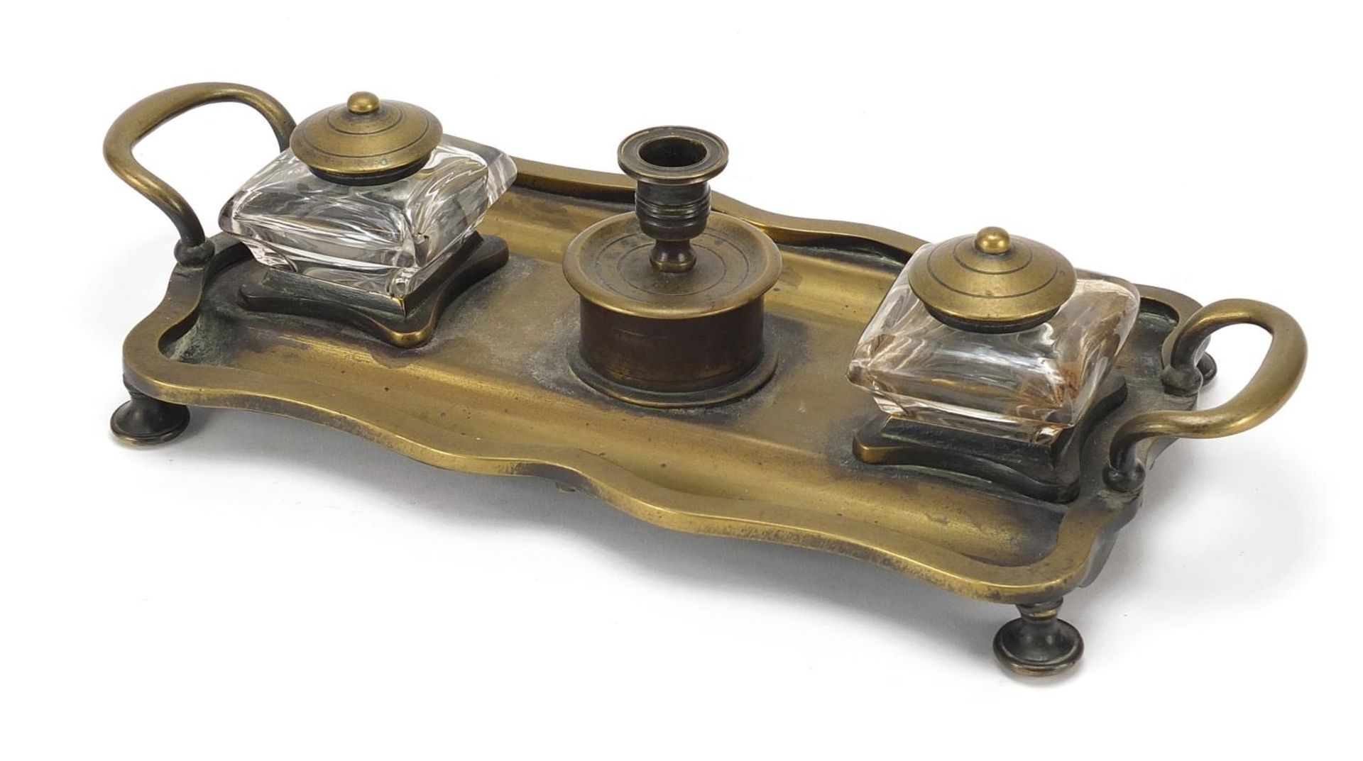 Victorian brass desk stand having two glass inkwells with brass tops, 27cm wide