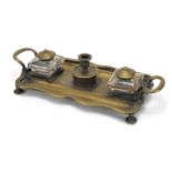 Victorian brass desk stand having two glass inkwells with brass tops, 27cm wide