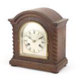 Oak cased striking mantle clock having a silvered dial and barley twist columns, 28cm high
