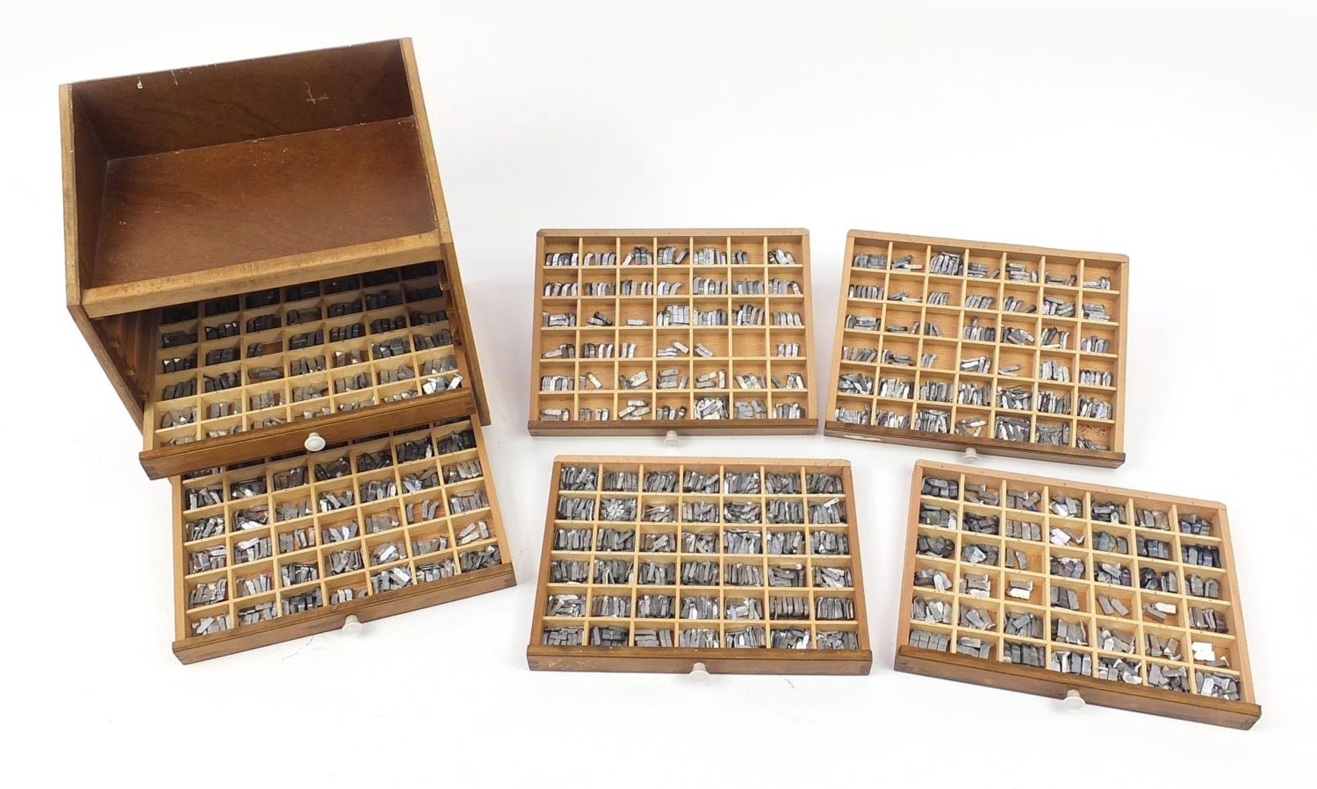 Large collection of metal printer's blocks letterpresses arranged in a six drawer table top cabinet