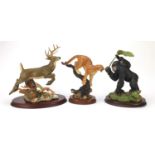 Three Franklin Mint porcelain figure groups to include a leaping stag, gorilla with a baby and a