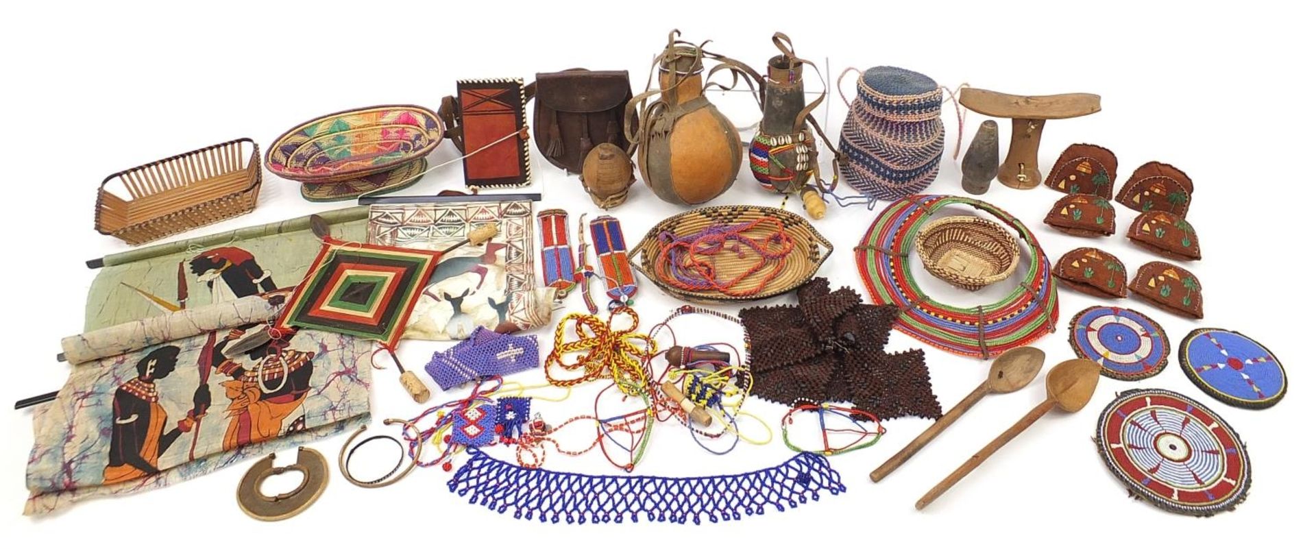 Tribal interest items including a carved wood headrest, gourd vessel with beadwork, tie-dye panels