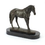 Patinated bronze horse raised on a black slate base, 33cm in length