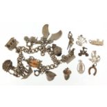 Silver charm bracelet with a selection of mostly silver charms including opening fireman's helmet,