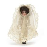 19th century bisque articulated doll wearing a white lace dress, 10cm high