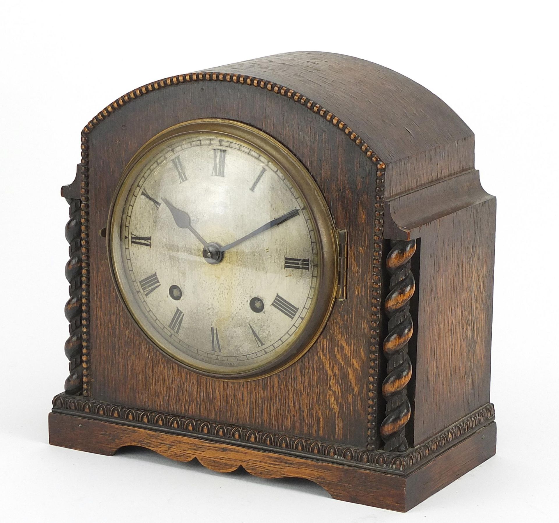 Oak cased striking mantle clock with silvered dial and barley twist columns, 23cm high