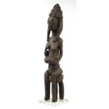 Large African Tribal interest carving of a nude tribeswoman feeding, probably from Western Sudan,