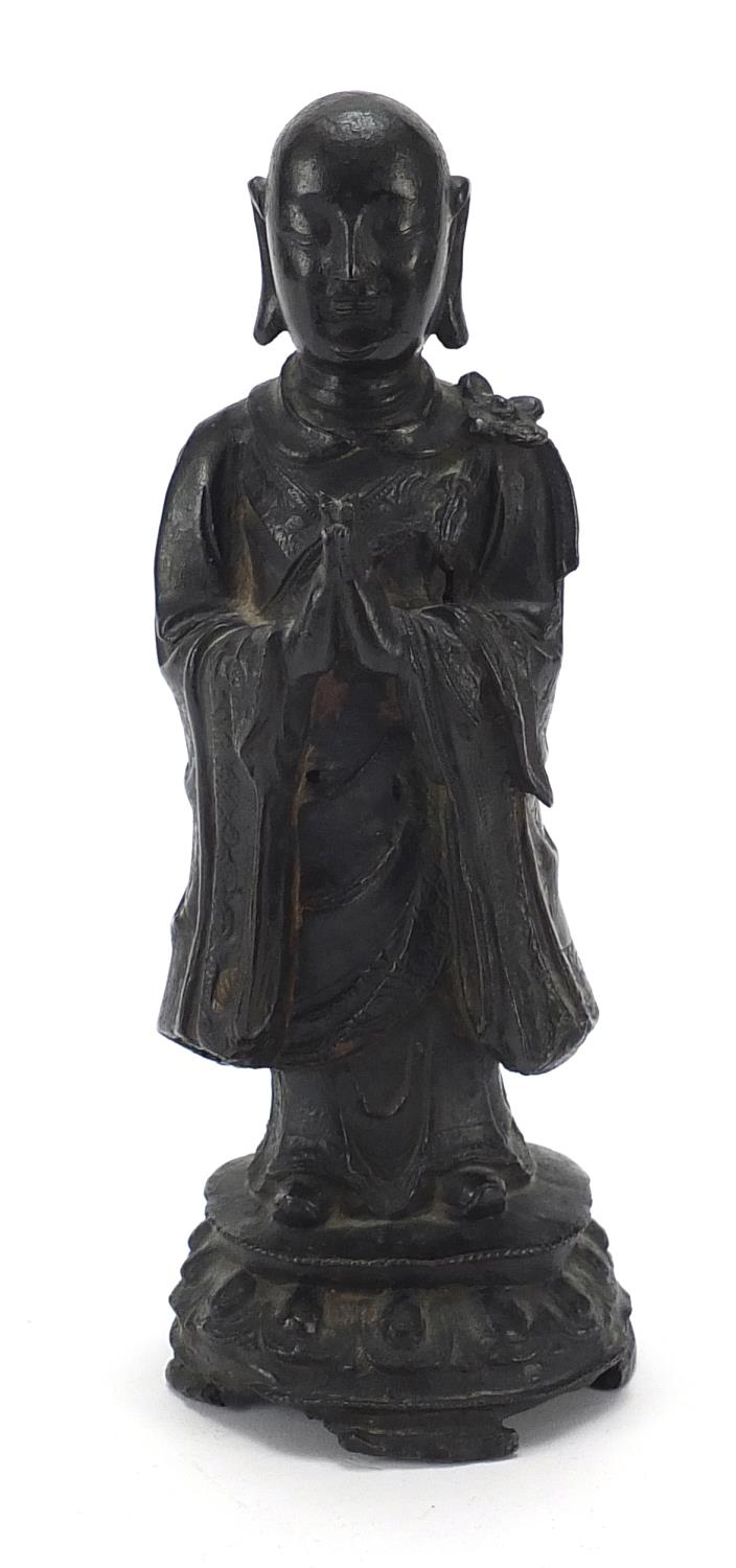 Chinese patinated bronze figure of a standing monk, 24.5cm high