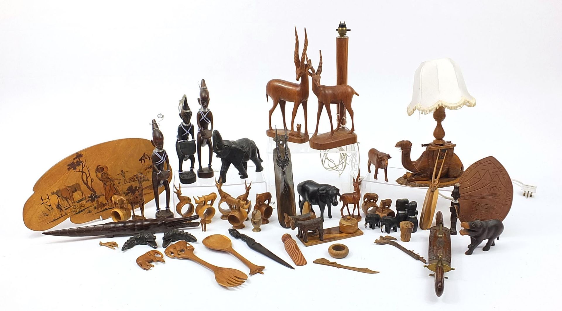 African woodenware to include carved elephants, table lamp, wall plaque, figures and a carving