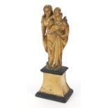 Antique ivory carving of Madonna and child raised on an ebonised and ivory base, 14cm high