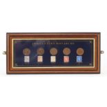 Glazed display of 20th century Monarchs pennies and stamps with certificate of authenticity,