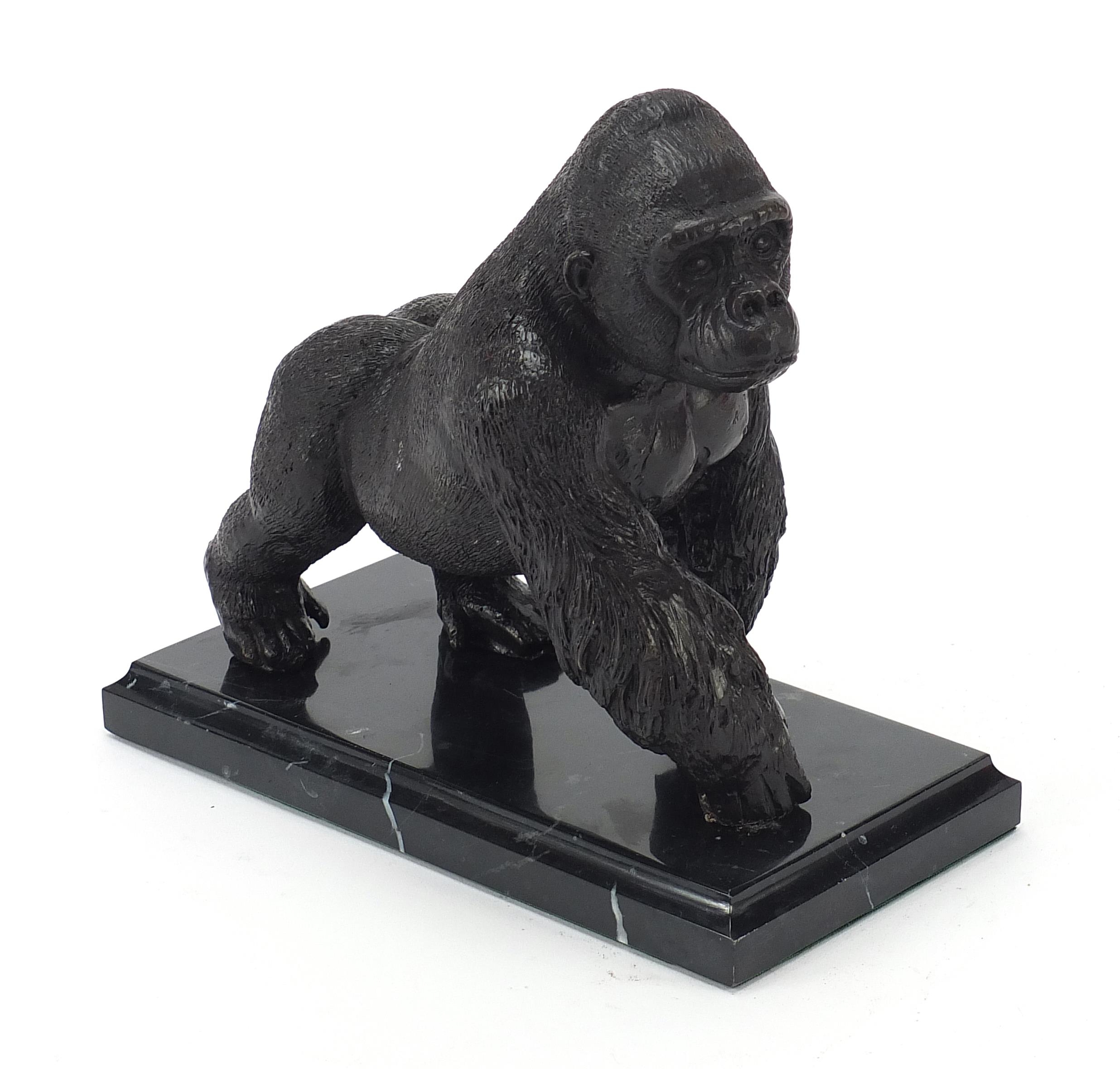 Patinated bronze gorilla raised on a black marble base, 20cm wide