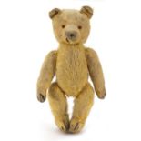 Antique golden straw filled teddy bear with articulated limbs, 29cm high