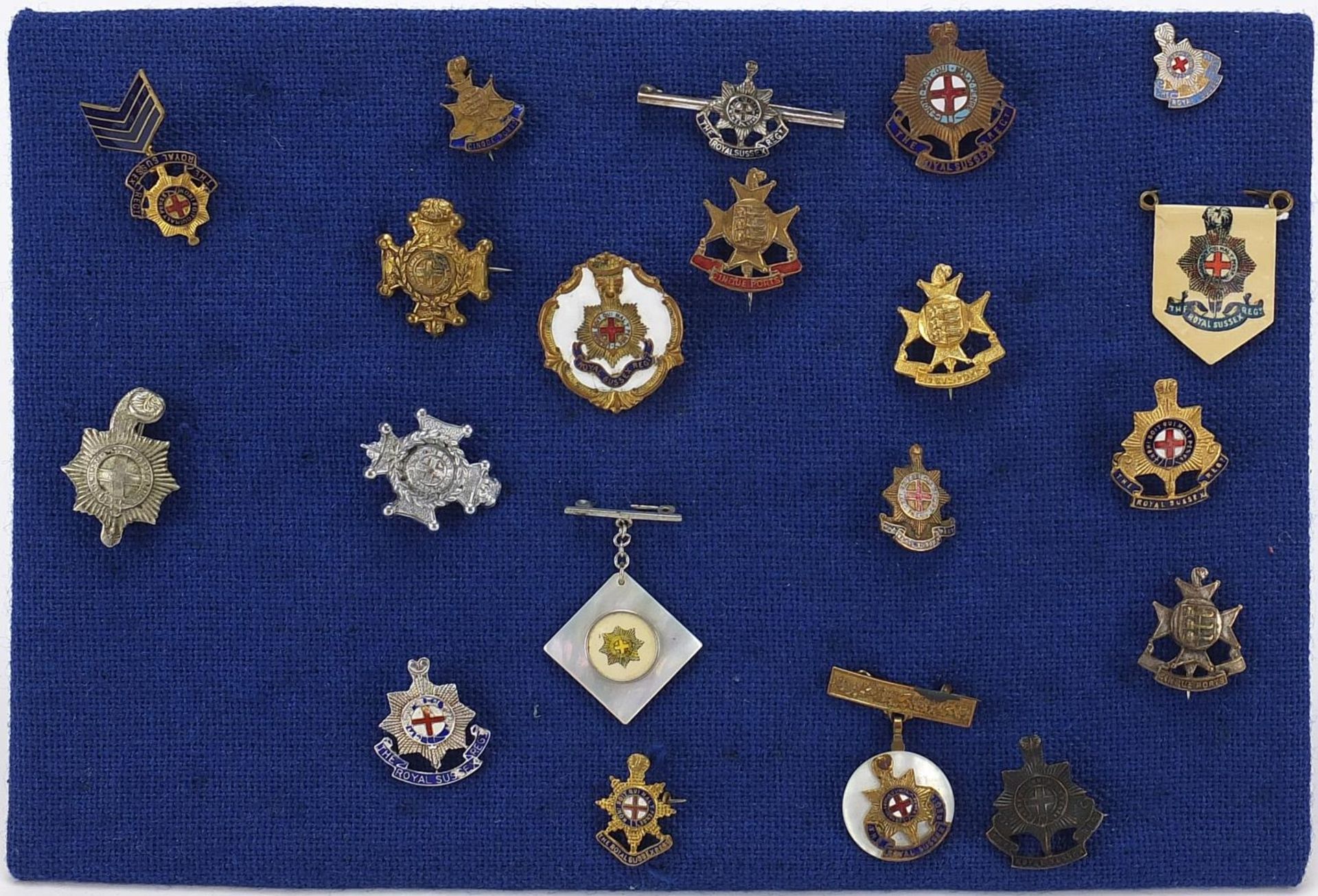 Twenty British military badges including Royal Sussex and Cinq Ports brooches including enamel and