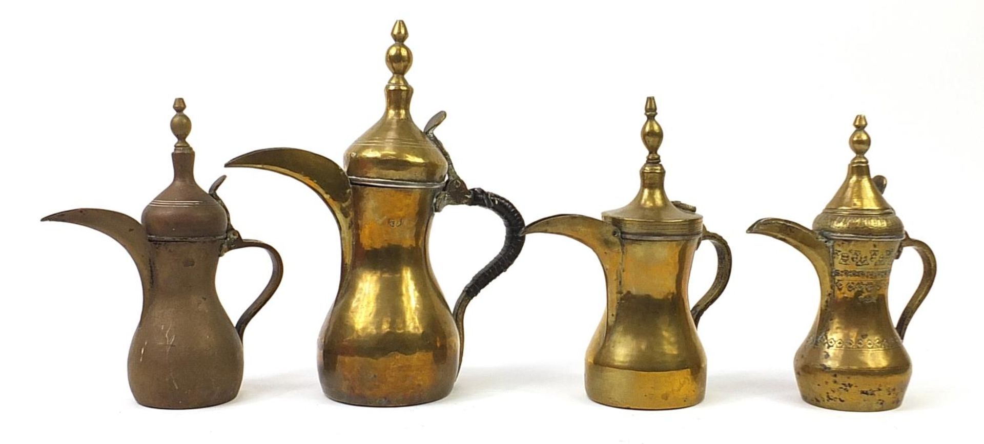 Four Imani brass dallah coffee pots, some with impressed marks, the largest 39cm high