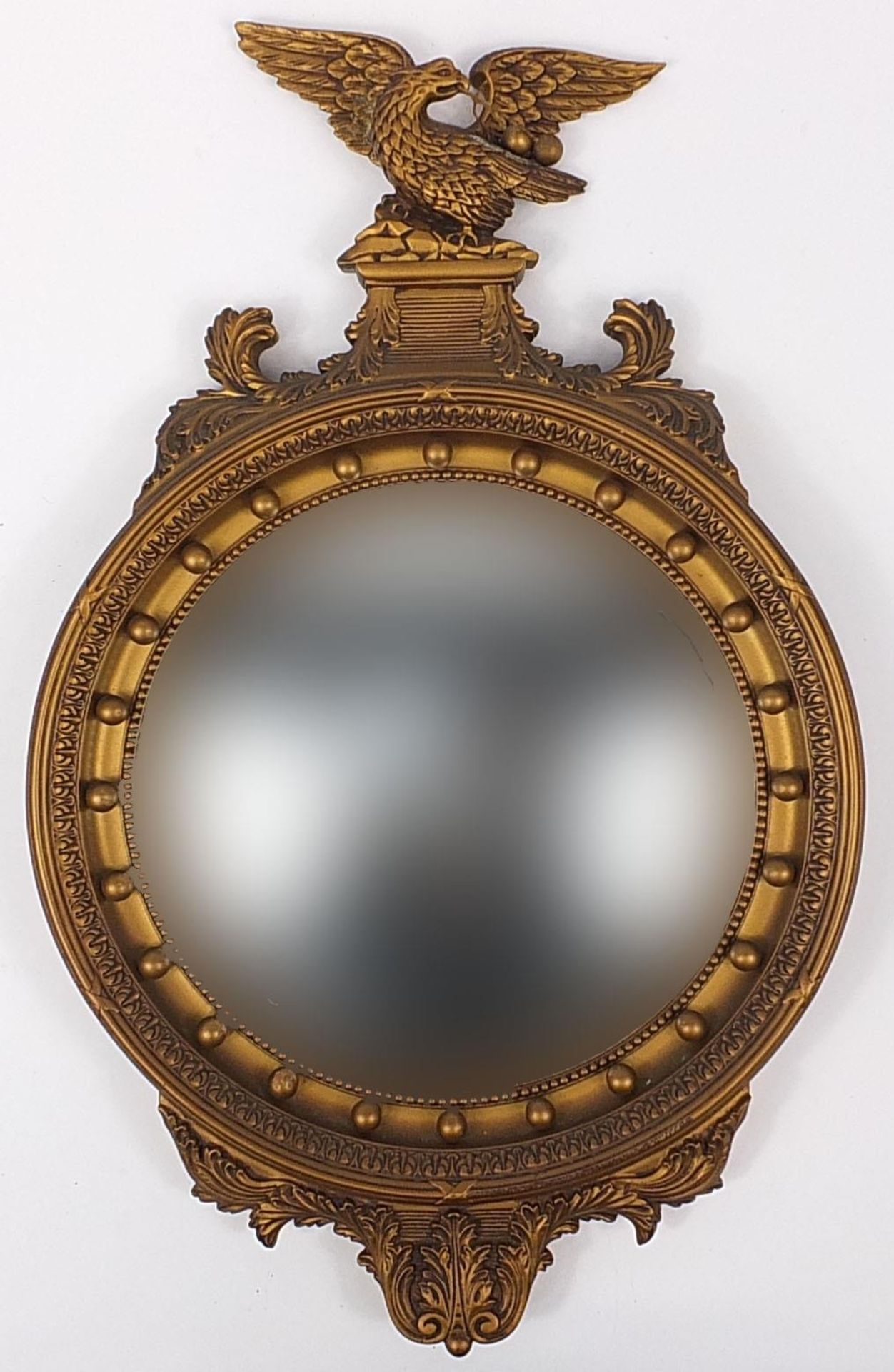 Gilt framed convex mirror with eagle crest, 67cm high x 42cm wide